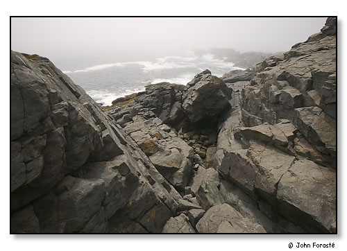 Coast, rock cliffs, surf and distant morning fog. Monhegan Island, Maine. July 2004.