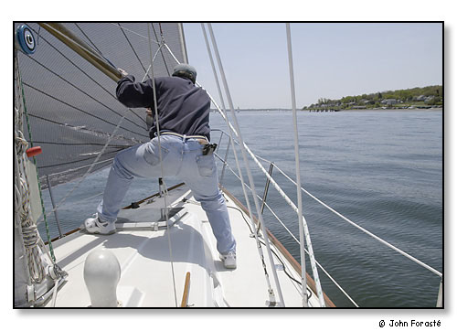 Sailor on deck of Pegassus, a Saber 36, during race. On Narragansett Bay, Rhode Island. May 2003.