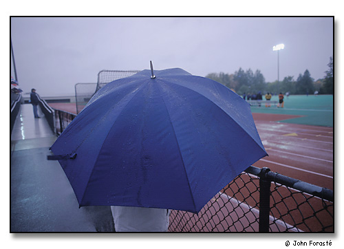 Blue umbrella at soccer night game in rain. <br>Skidmore College, Saratoga Springs, New York. October 2002.